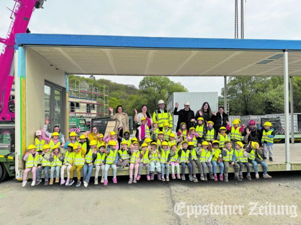 Die Kindergartenkinder, professionell ausgerüstet mit Baustellenhelm und gelber Warnweste, nahmen Platz in einem der 18 Meter breiten Einzelmodule für die neue Kita. Foto: S. Reulecke