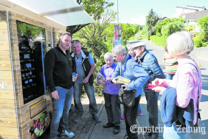Dirk Stavonhagen und Eckart Hermann helfen den ersten Käufern Marie und Christoph Müller (v.li.) am neuen Automaten.Foto: Beate Schuchard-Palmert