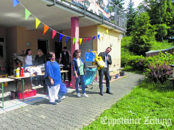 Bürgermeister Alexander Simon übergibt Leiterin Sandra Erkrath einen Spielzeug-Bagger für die Kinder. Foto: Stadt Eppstein