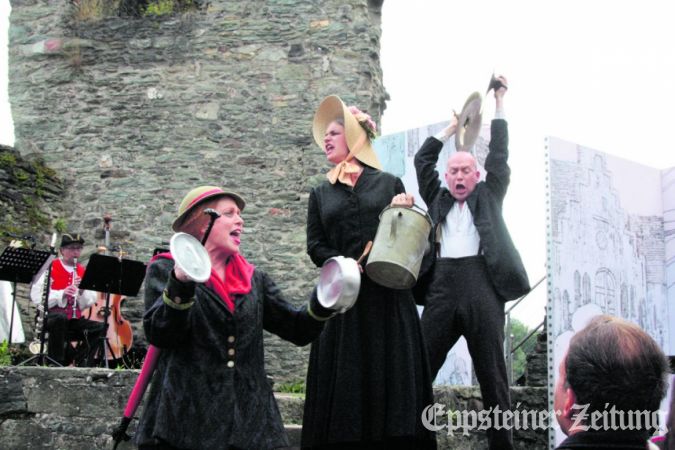 Die Frau mit dem Regenschirm (Ulrike Kinbach), das Ginnheimer Meedsche (Randi Rettl) und der Aufwiegler aus Berlin (Andreas Jahncke) protestieren mit Kochtopf und Gießkanne. Foto: Julia Palmert