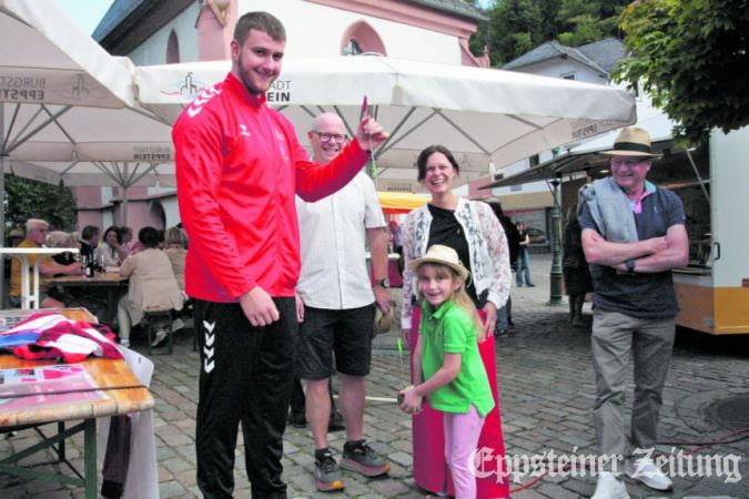 Pauline (6) hält das Wurfgerät des Hammerwerfers Tim Steinfurth, das eigentlich eine Kugel ist.
            Foto: Beate Schuchard-Palmert
