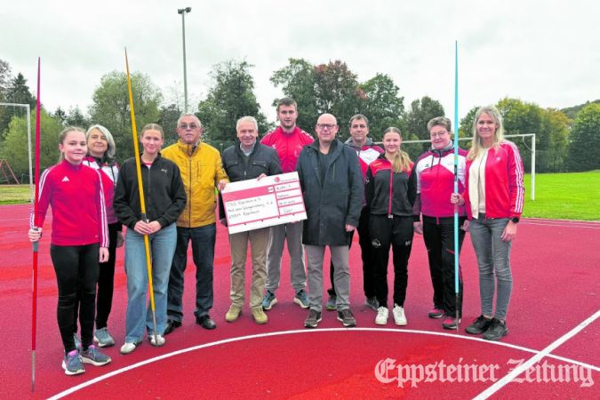 Landrat Michael Cyriax (5. v.l.) bei der Scheckübergabe an den Vorsitzenden der TSG, Manfred Helbig (5. v r.). Zum Treffen waren auch Speerwerferinnen des Vereins und weitere Leichtathleten wie der Deutsche Meister Tim Steinfurth (Mitte) gekommen.
            Foto: MTK-Pressestelle