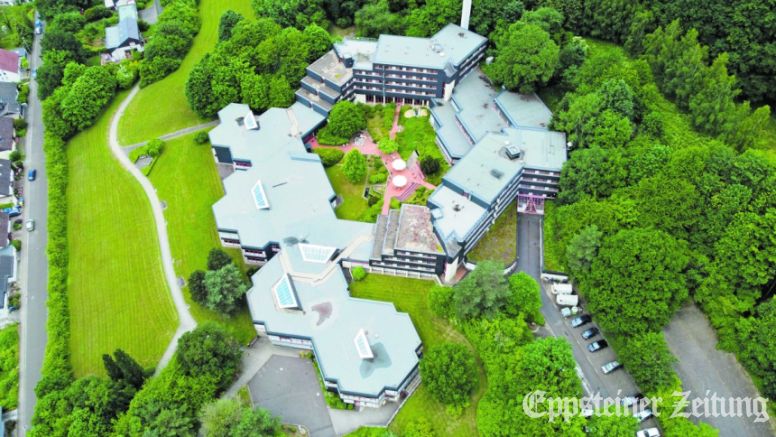 Die Luftaufnahme der GWH zeigt die ungewöhnliche Architektur des Akademiegebäudes, das sich in den Hang hinein zu schmiegen scheint. Foto: GWH-Bauprojekte