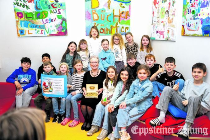 Büchereileiterin Christina Cantzler ist umringt von den Jungen und Mädchen aus der Klasse 4c, die ihr den Erlös aus ihrem Frühstücksverkauf überreichen.Foto: Jonas Schönian