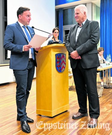 Bürgermeister Alexander Simon (l.) übergibt dem neuen Stadtrat Dr. Christian Weiser die Ernennungsurkunde. Im Hintergrund: Stadtverordnetenvorsteherin Eva Waitzendorfer-Braun.Foto: Stadt Eppstein