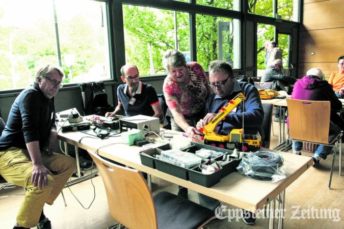 Klaus Christ (re.) und Karin Cloos tüfteln am Spielzeug-Kran, von den Kollegen Stephan Fliegel und Thomas Adams (v. li.) gibt es gute Ratschläge.Foto: Beate Schuchard-Palmert